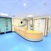 A hospital corridor with blue floor.  