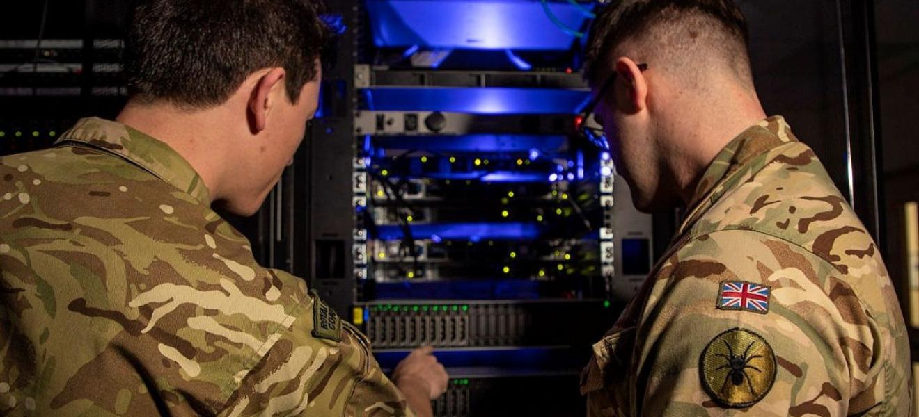Two men in military fatigues looking at a server