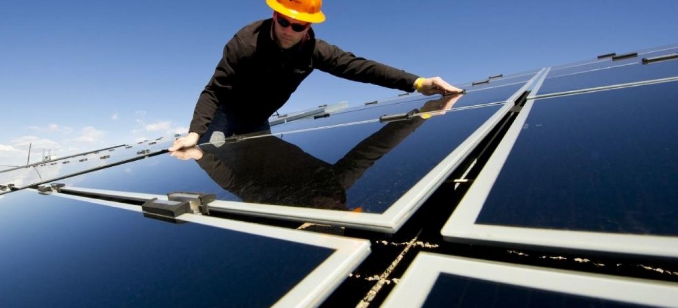 An engineer installing solar panels on a roof