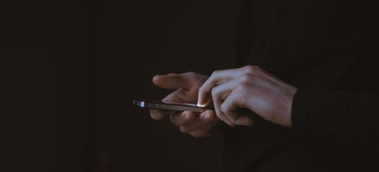 A person using a phone in a dark area