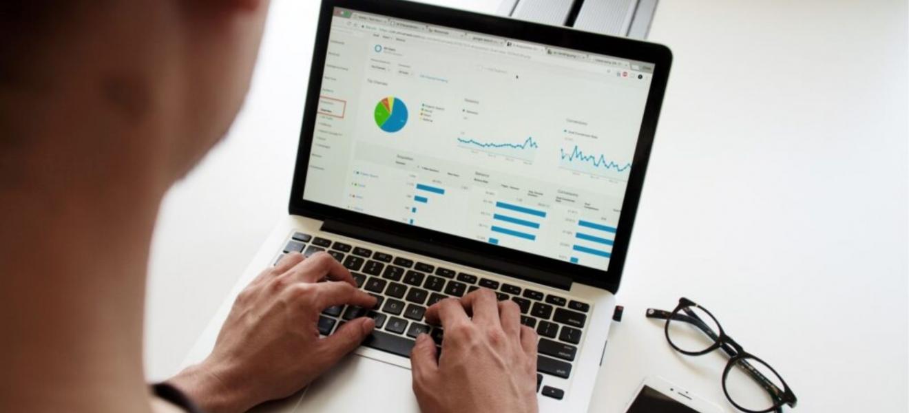 A person using a laptop to look at graphs A person using a laptop to look at graphs