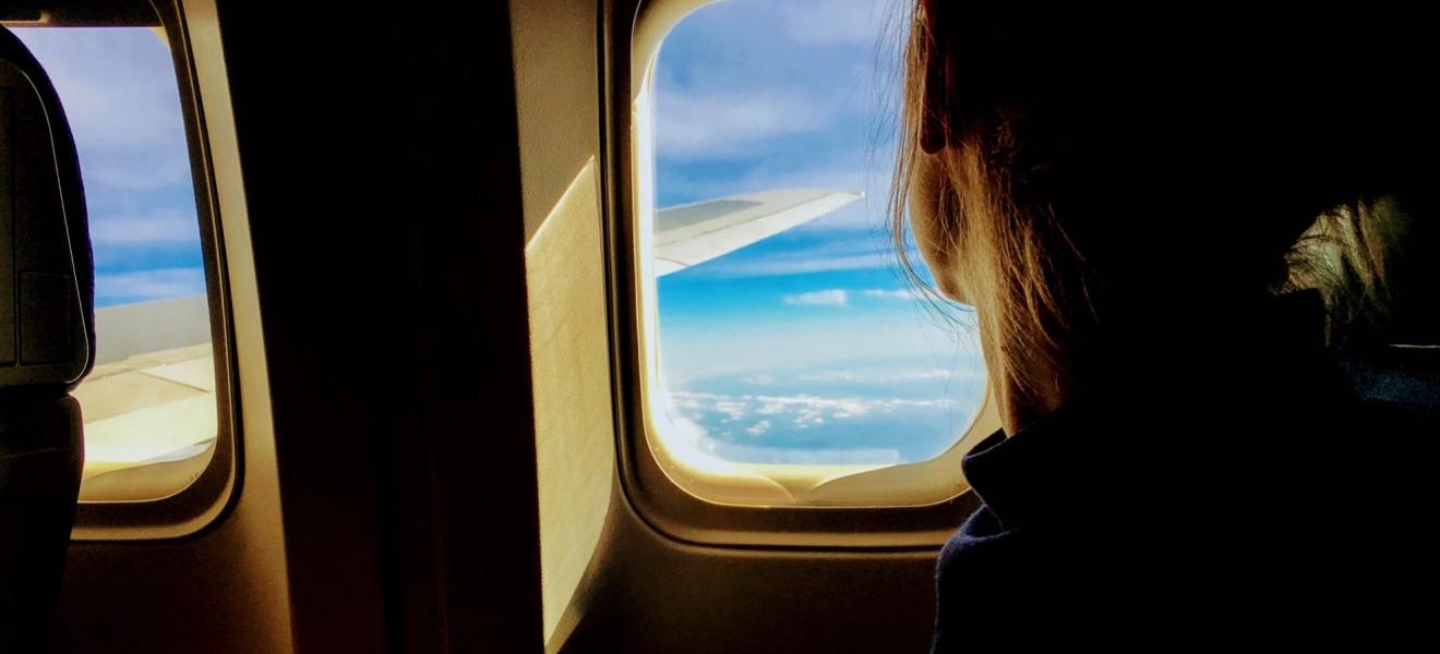 A girl looking out the window of a plane