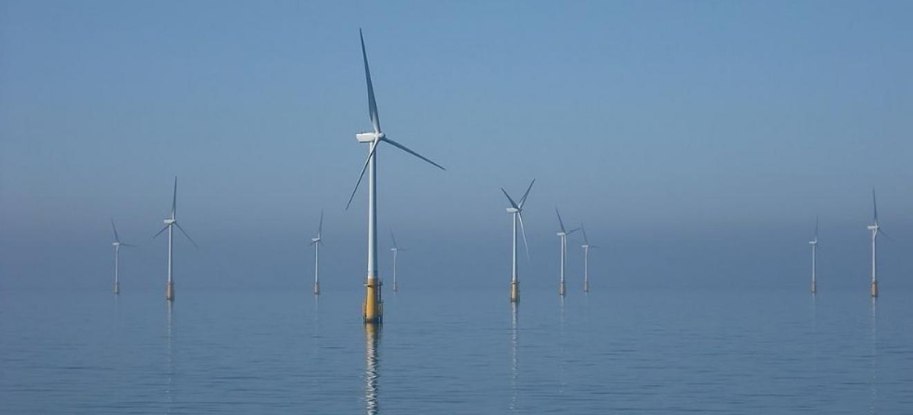 Image: Andy Dingley, edit Muhammad on WikiCommons https://commons.wikimedia.org/wiki/File:Barrow_Offshore_wind_turbines_NR.jpg Wind turbines offshore with a blue sky and calm sea