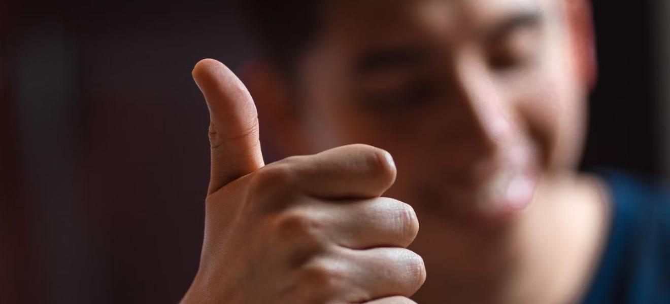 A man doing a 'thumbs up' gesture A man doing a 'thumbs up' gesture