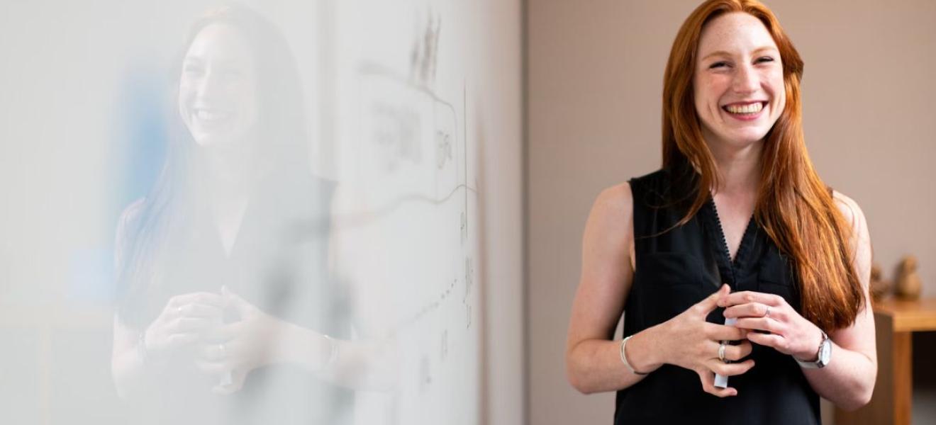 Female software engineer in meeting by whiteboard