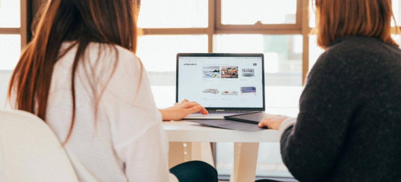 Two women using a laptop at a desk