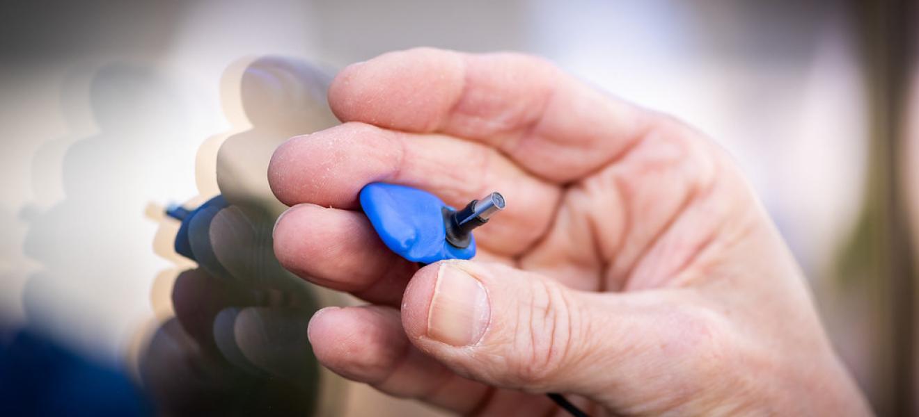 Somebody holding a prototype of the earswitch device