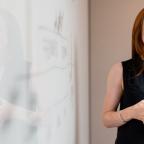 Female software engineer in meeting by whiteboard