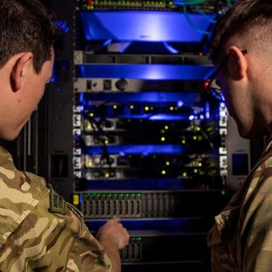 Two men in military fatigues looking at a server