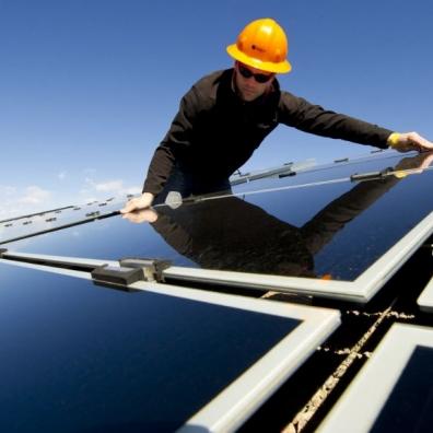 An engineer installing solar panels on a roof