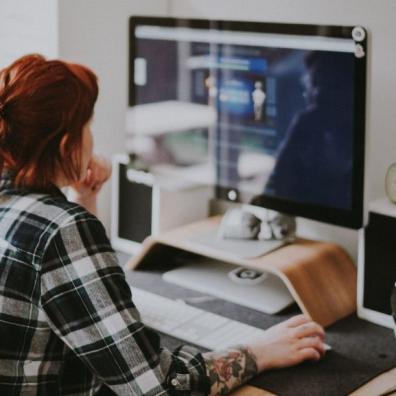 A woman working from home with a large monitor