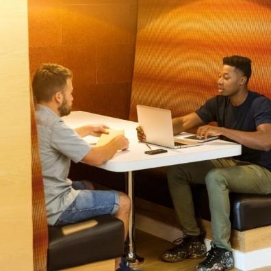 Two men in a working hub using a laptop