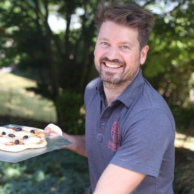 Harry Singer with a pizza