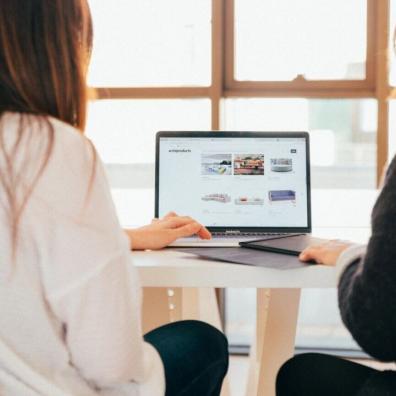 Two women using a laptop at a desk