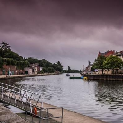 Exeter quay, the river flowing below purple, brooding skies 