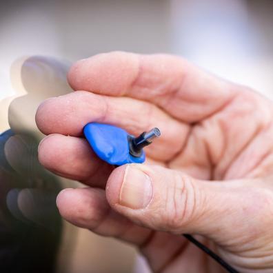 Somebody holding a prototype of the earswitch device